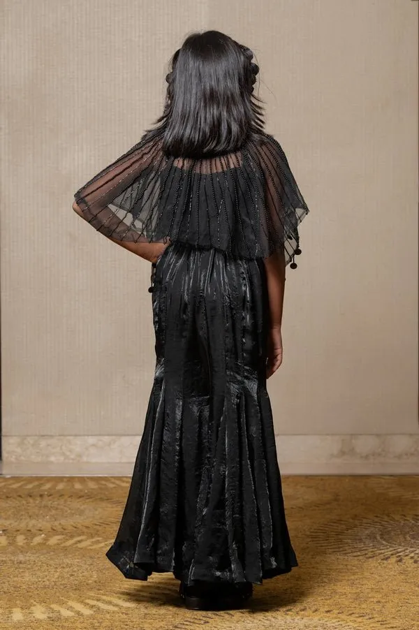 Chic black ensemble with a beaded cape and flared pants, perfect for making a stylish statement at any occasion